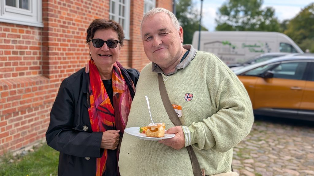 Teilnehmerin und Teilnehmer mit Kuchen auf dem Schlosshof