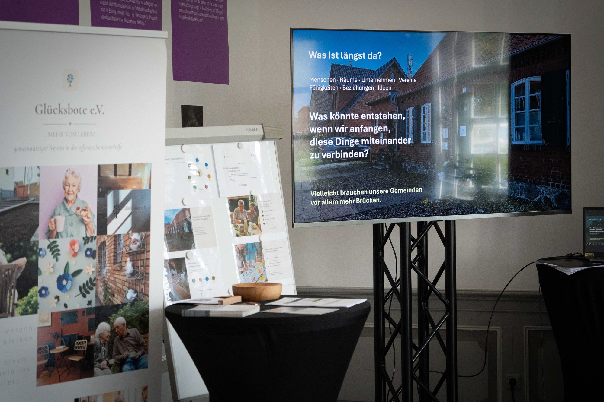 Stand des Glücksbote e.V. mit Bildschirm: Was ist längst da?