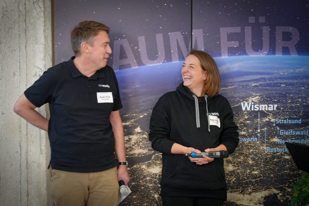 Rea Engel und Axel Fick vor der Wand des InnovationPort