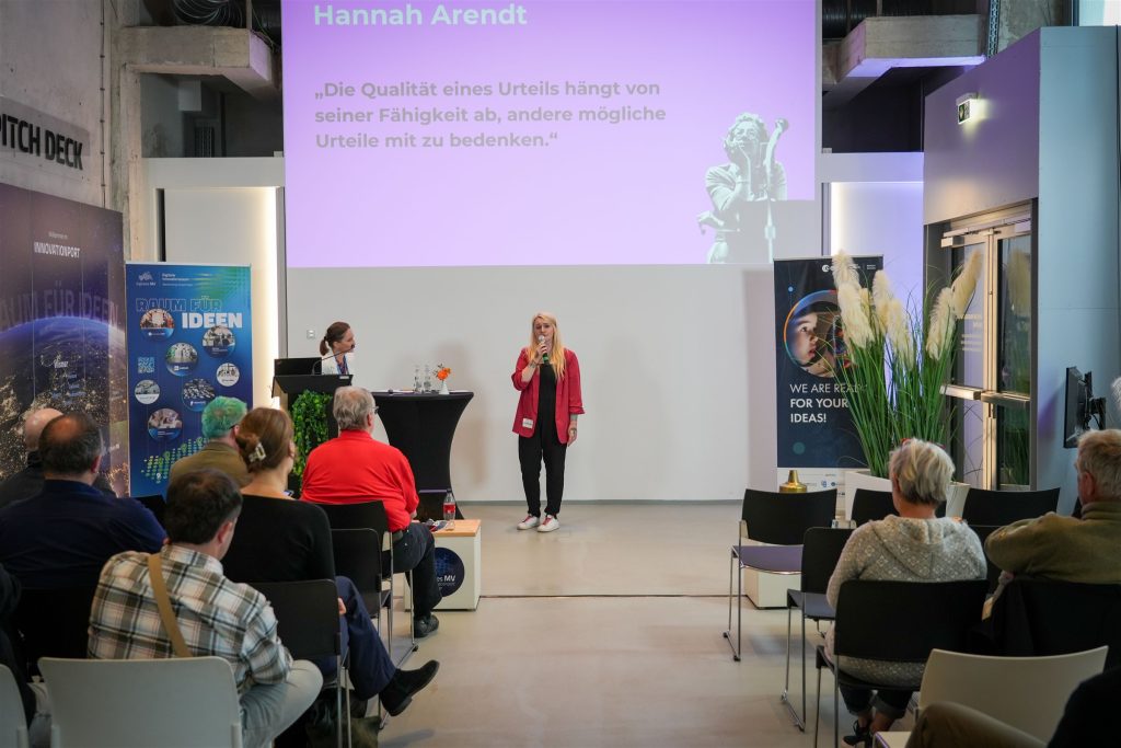 Christine Bach vor einer Folie mit einem Zitat von Hannah Arendt